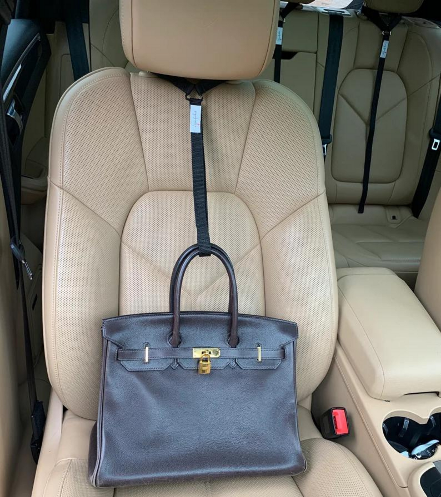 Stop the useless soccer mom arm move.   Get a Strap for that and prevent your passenger seat purse spills forever